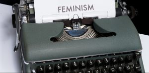 היררכיה פמיניסטית: מי כותבת את הסיפור מיוצג בידי תמונה של מקלדת עם הכיתוב פמיניזם