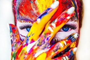 אישה מכוסה צבעים מייצגת מטפלות באמנות