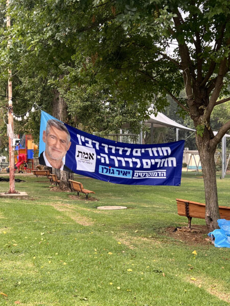 שלט של מפלגת הדמוקרטים מחוץ לקלפי במועדון לחבר בקיבוץ דן